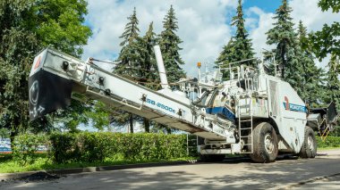 Kaldırımın kenarında, ağaçların arka planında beyaz bir kaldırım var.