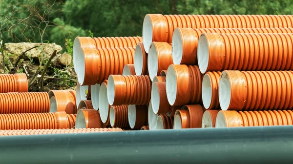 orange corrugated pipes for sewage at a construction site