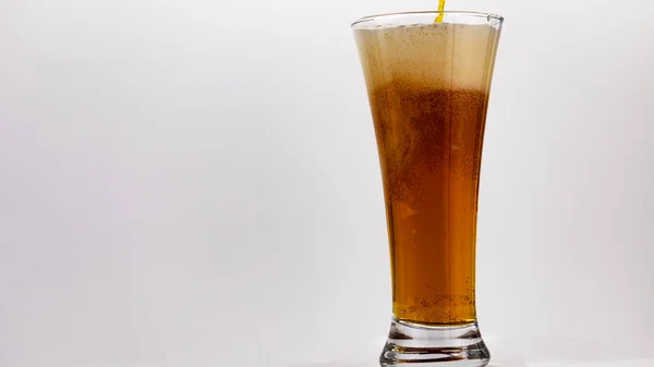 beer is poured into a glass on a white background,soft focus