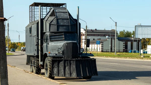 Kazıcıdan büyük bir bıçakla siyah bir kamyon.
