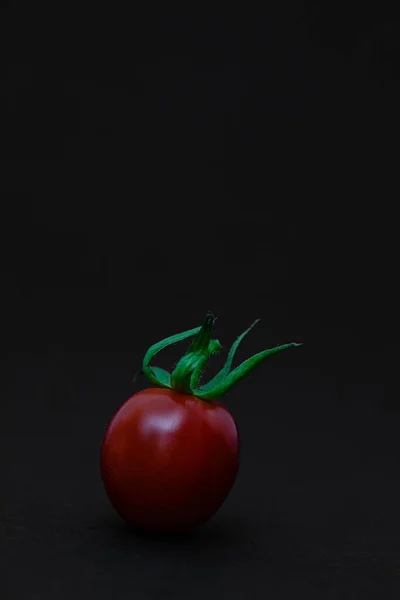 Κόκκινο Tomate Πράσινα Ξηρά Φύλλα Μπροστά Από Ένα Μαύρο Φόντο — Φωτογραφία Αρχείου