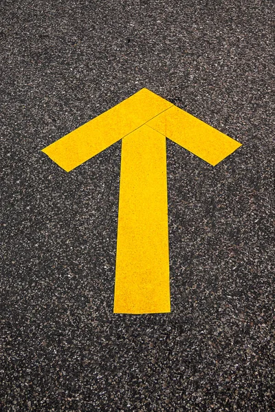 yellow tape forming an arrow glued on the street
