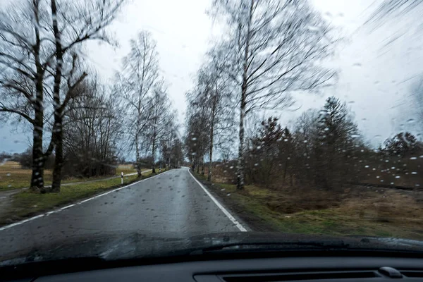 Issız bir kır yolunda araba sürmek ve kışın kötü hava.