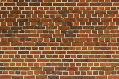 Kırmızı, turuncu ve kahverengi tonlarda çok renkli tuğlalarla donatılmış klasik kahverengi dış duvar dokusu ve İngiliz tahvil kalıpları.