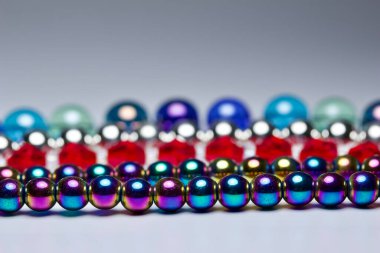 Macro art abstract texture background of colorful defocused necklace beads in row patterns with bokeh, and copy space