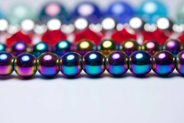Macro art abstract texture background of colorful defocused necklace beads in row patterns with bokeh, and copy space