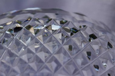 Macro abstract art texture background of beautiful sparkling lead crystal glass with hand-cut diamond facets, reflecting natural light