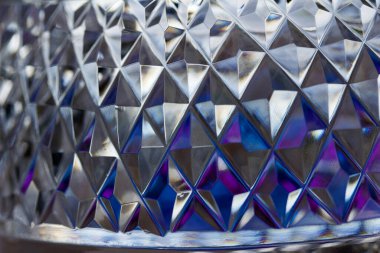 Macro abstract art texture background of beautiful sparkling lead crystal glass with hand-cut diamond facets, reflecting natural light