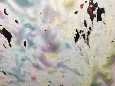 Close up abstract texture background of an automated car wash from inside the car, with bright colorful soap suds