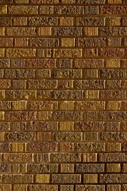 Vintage brown brick wall background with textured bricks with a hint of green color