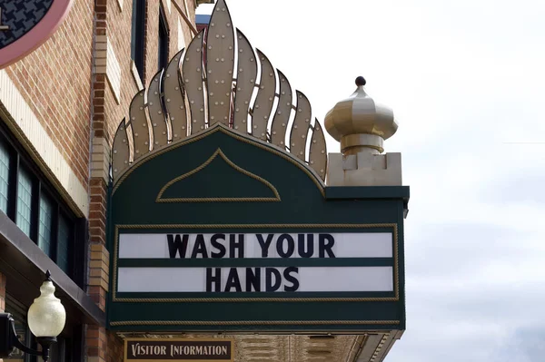 Faribault, Minnesota, ABD - 26 Mart 2020: Covid-19 sağlık ve güvenlik tavsiyesi içeren levhalı şehir merkezi sinema markisi.