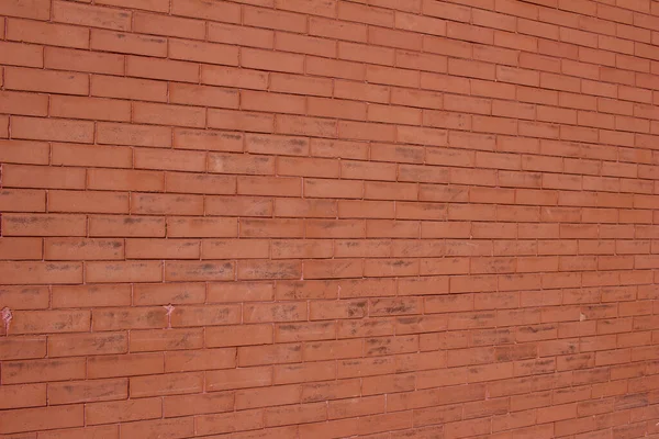 Vintage brick wall texture background with weathered burnt orange color bricks with a scuffed and stain surface