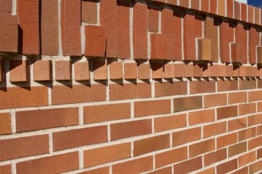 Tuğla duvar dokusu arka planda modern geleneksel kil tuğlalar ile süslenmiş geometrik dizayn dizaynları güneş ışığını yakalayan tuğlalar