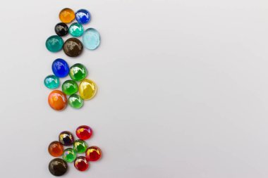 Beyaz zemin üzerinde renkli ejderha gözyaşlarının (cam damlaları) soyut sanat kenarı arka planı