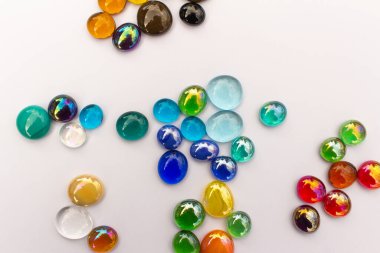 Beyaz zemin üzerinde renkli ejderha gözyaşlarının (cam damlaları) soyut sanat arkaplanı ve kopyalama alanı