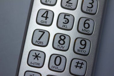 Tuş takımının soyut doku görünümünü gümüş renkli, kablosuz bir telefon ahizesi üzerinde kapat