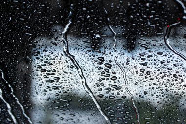 Otomatik araba yıkama sırasında arabanın ön camındaki su damlacıklarının soyut doku görünümü