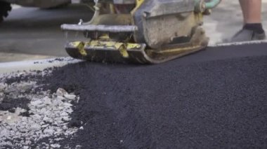 Kaldırımdaki titreşimli asfalt kaldırım makinesi HONDA yakın plan çekimleri. Yol çalışmaları, kaldırım tamiri, sıkı çalışma. Video klibi..