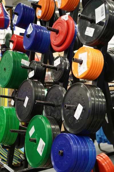 Sports goods sale in store,colorful weight plates.Healthy lifestyle concept,sports training.Close-up colorfull barbell plates.