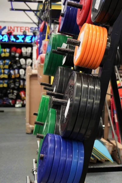 Sports goods sale in store,colorful weight plates.Healthy lifestyle concept,sports training.Close-up colorfull barbell plates.