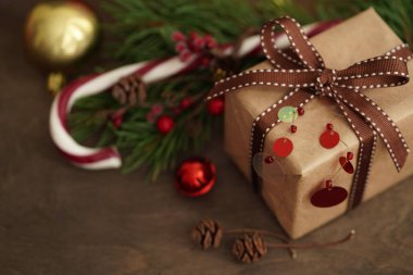 Noel süslemeleri. Hediye kutusu, Noel şekeri, köknar dalları, tahta arka planda toplar, seçici odaklanma. Noel ve yeni yıl kavramı.