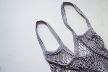 Alışveriş torbası torba ağ torbası gri beyaz mermer zemin, düz yatış, üst manzara. Sıfır atık kavramı