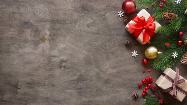 Noel ya da yeni yıl arkaplanı, Noel süslemelerinin basit kompozisyonu hediye kutuları, toplar, koniler, kar taneleri ve köknar dalları ahşap arka planda, düz yatış, karşılama metni için boş alan, kopyalar.