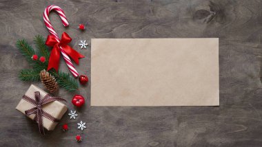 Noel ya da yeni yıl arkaplanı, Noel süslemeleri hediye kutularının basit kompozisyonu, kırmızı toplar, koniler, lolipoplar ve ahşap zemin üzerinde köknar dalları, düz yatış, karşılama metni için boş alan, kopyalama küresi