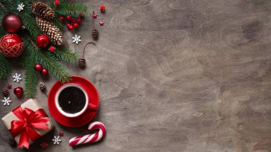 Noel arkaplanı, Noel süslemesi hediye kutularının basit kompozisyonu, kırmızı fincan kahve, toplar, lolipoplar ve tahta arka planda köknar dalları, düzlük, karşılama metni için boş alan, fotokopi küresi.