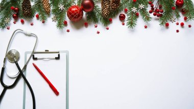 Beyaz arka planda noel bayrağı dalları, koniler, kırmızı toplar, kar taneleri, steteskop ve tablet. Kopyalama. Tıbbın yeni yılı.