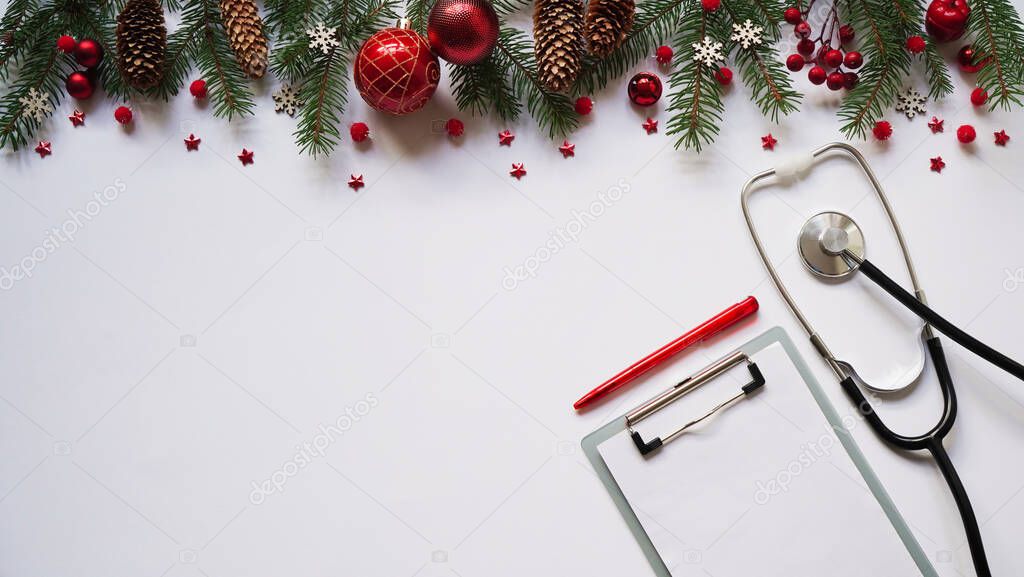Christmas medical banner fir branches, cones, red balls, snowflakes, stethoscope and tablet on white background top view. Copyspace. Medicine new year flatly.