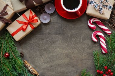 Noel veya yeni yıl arkaplanı, Noel süslemeleri hediye kutuları, toplar, koniler, kahve ile kırmızı bardak, lolipoplar ve köknar dalları eski ahşap arka planda, düz yataklar, fotokopi kürekleri, üst wiew.
