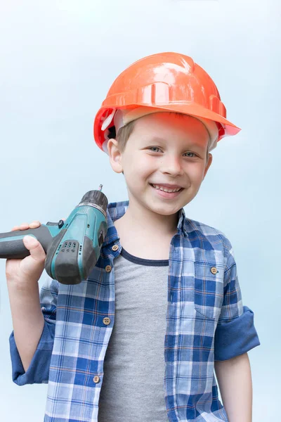 Ein Fröhlicher Lächelnder Junge Mit Orangefarbenem Bauhelm Und Einem Elektroschrauber — Stockfoto