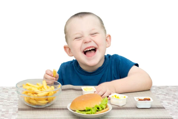 Een Kleine Jongen Zit Aan Een Tafel Waar Gebakken Hamburger — Stockfoto