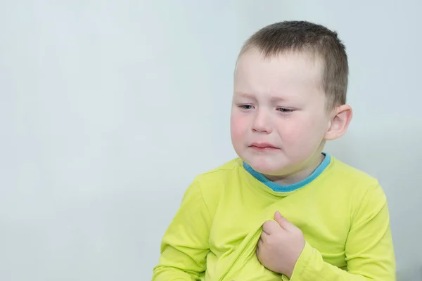 一个伤心的 哭泣的 眼里含着泪水的孩子把目光移开了 穿着黄色衣服的男孩 背景浅 水平照片 这种想法是孩子气的怨恨 — 图库照片