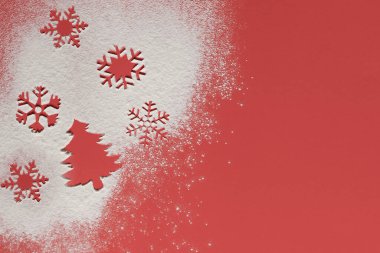 Bir Noel ağacı ve dökülen un üzerine dökülen kar taneleri. Kırmızı arka plan, beyaz un kara benziyor. Noel arkaplanı. Noel duvar kâğıdı. düz yat.
