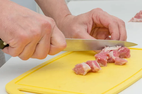 まな板に鋭いナイフで新鮮な肉を切断男の手のクローズアップ 肉料理の調理の概念 キッチンであなたの妻を助ける 男の料理 — ストック写真