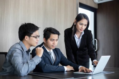 Asyalı işadamları ve grup iş ortakları için not defteri kullanıyor toplantıda belgeler ve fikirler tartışıyorlar ve iş kadınları mutlu bir şekilde gülümsüyorlar. 