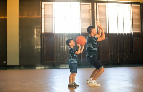 Asyalı bir aile birlikte basketbol oynuyor. Mutlu aile tatilde birlikte vakit geçiriyor.