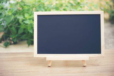  Ahşap masa üstü güneşle tahtada siyah ve yeşil ağaç bokeh arka plan, şablon ürün görüntüleme için sahte bulanıklık