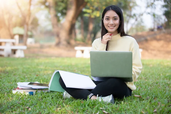 Asijské Ženy Vysokoškoláků Usmíval Sedí Zelené Trávy Pracovní Čtení Mimo — Stock fotografie