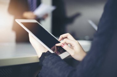 İşadamları ve belgeler ve fikirler toplantısında tartışırken iş ortakları için dizüstü ve tablet kullanarak grubu 