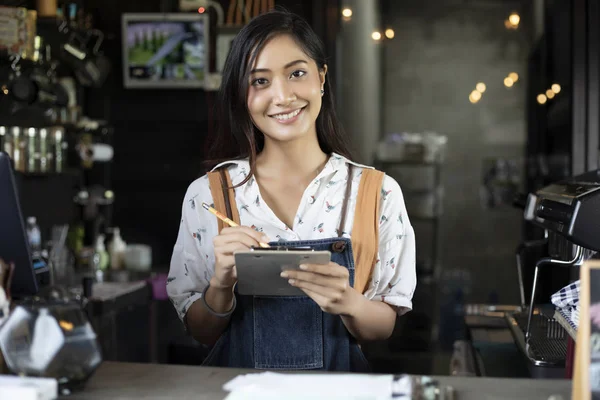 Happy smiling asian barista, girl behind counter, working with POS terminal  and brewing filter kit Stock Photo by benzoix