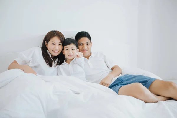 Happy Asian family with son at home on the bedroom playing and laughing