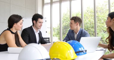 İşadamları ve mühendis grubu belgeler ve fikir toplantı ve çalışma için mutlu gülümseyen iş kadınları olarak tartışırken iş ortakları için defter kullanma 