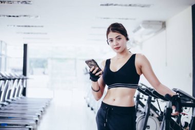 Asya atlet spor giyim moda giyim. Sporcumuz fitness etkinlik izleyicisi - kalp oran sınıf başkanı Smartphone'da onun sağlık ilerleme izleme telefon app kullanarak müzik dinlemek. 