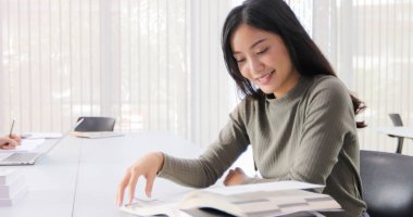 Asyalı kadınlar öğrenciler gülümseme ve kitap okuma ve fikirler iş ve proje paylaşmak için yardımcı olur için defter kullanma. Ve ayrıca sınav öncesi Kitap İnceleme