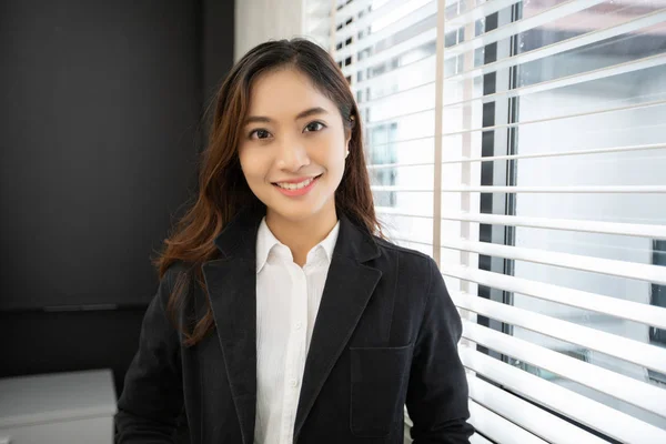 Portrait of Asian businesswomen standing at bright office and smiling