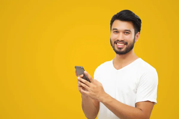 Asiatiska Affärsman Leende Medan Använder Smartphone Gul Bakgrund — Stockfoto
