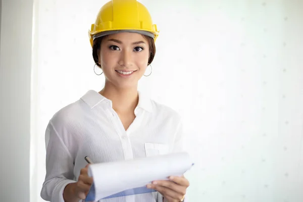 Asiatin Mit Hardhat Hält Baupläne Büro — Stockfoto